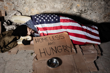 Man with alms bowl sleeping under American flag