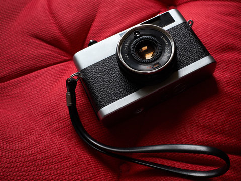 Isolated film camera with hand strap.