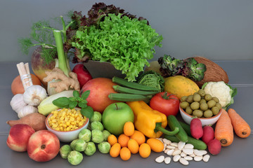 Alkaline health food of fresh vegetables, fruit, herbs, spice and dried legumes on grey wood table background. High in antioxidants, anthocyanins, fibre, minerals and vitamins.  