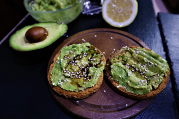 Avocado toast , overhead viewy avocado sandwich on toast bread made with fresh avocado paste on the black background