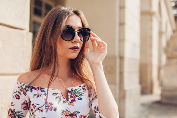 Outdoor portrait of young beautiful fashionable woman wearing stylish sunglasses. City fashion. Makeup