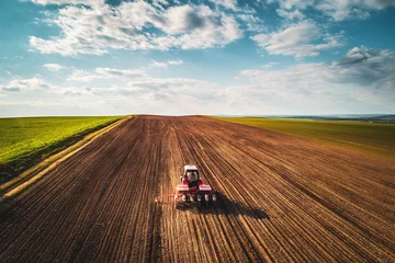 Crédence de cuisine en verre imprimé Tracteur Agriculteur avec tracteur semant des cultures sur le terrain, vue aérienne