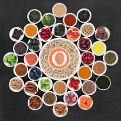 Large health food wheel with foods to slow the ageing process down. Very high in antioxidants, anthocyanins, dietary fibre and vitamins. On slate background top view.
