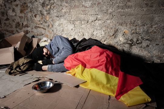 Man sleeping on the street under German flag