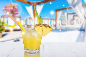 Fresh cocktail with pineapple on wooden table on graden