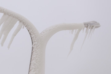 Street lamp covered with snow and huge icicles