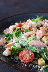 Smoked salmon salad with arugula, chard, sprinkled with grated cheese and bread chips