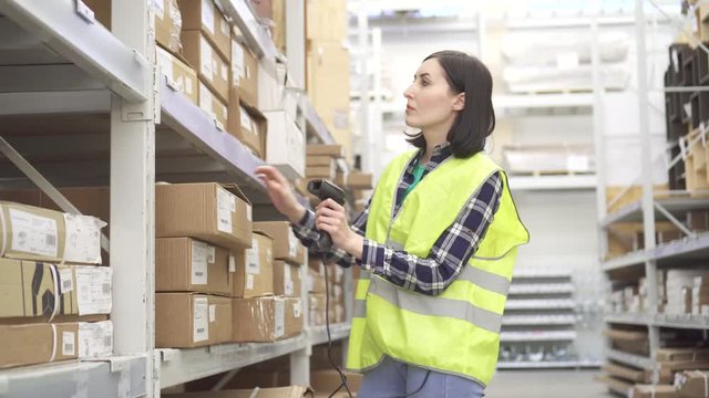 Store worker in the warehouse using a barcode scanner conducts accounting