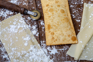 Fried pastel, dough and raw pastel, on rustic wooden table