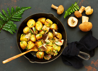 Baked potatoes with mushrooms in a frying pan.