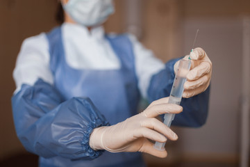 Doctor in medical gloves hold a syringe with an antibiotic. A nurse prepares to give an injection....