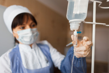 nurse in a hospital ward checks the counter drops. A female doctor takes care of the patient after...