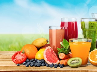 Tasty fruits  and juice with vitamins on background