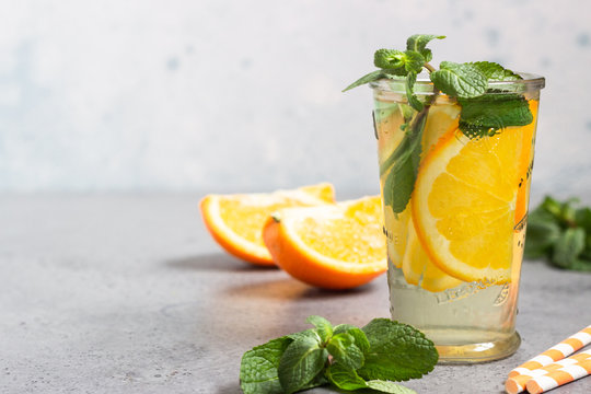 Glass with homemade orange lemonade with mint. Copy space for text.