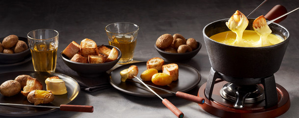 Panorama banner of a cheese fondue and sides
