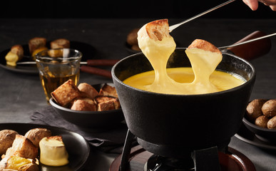 Dipping toast in a Swiss cheese fondue