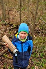 geocaching boy finds a well camouflaged cache in the forest