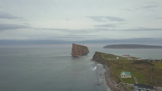 Aerial view of a beautiful modern town on the Atlantic Ocean Coast during a cloudy sunset. Taken in Perc&eacute;, Quebec, Canada.