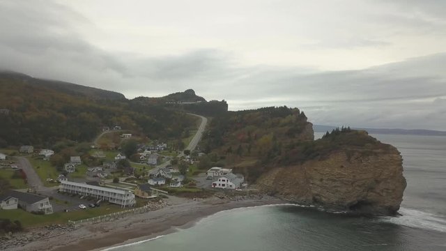 Aerial view of a beautiful modern town on the Atlantic Ocean Coast during a cloudy sunset. Taken in Perc&eacute;, Quebec, Canada.