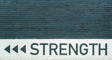 gray brick wall vith strength motto