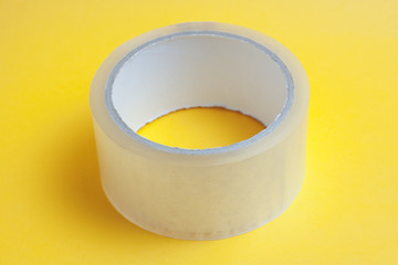 adhesive tape on yellow bright background. for use in the office and repair or building industry...
