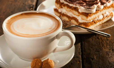 White ceramic cup of coffee with dessert