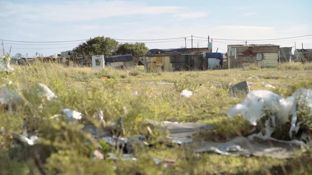 Garbage and plastic litter ourside an impoverished shanty town of tin shacks. South Africa.