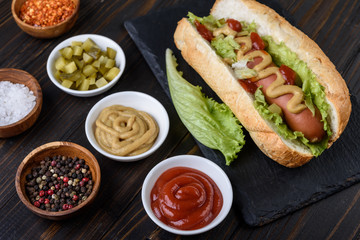 Tasty hot dogs with  mustard and  ketchup on wooden background