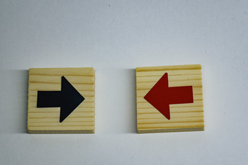 Wooden block with red arrow facing the opposite direction black arrows.