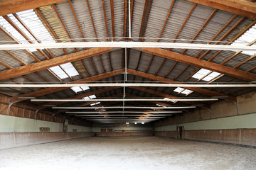 Panoramic view of an empty indoor horse riding arena