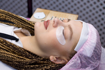 Eyelash Extension Procedure. Woman face with Long false Eyelashes. Close up macro shot of fashion...