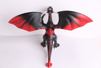 black and red dragon toy on white background