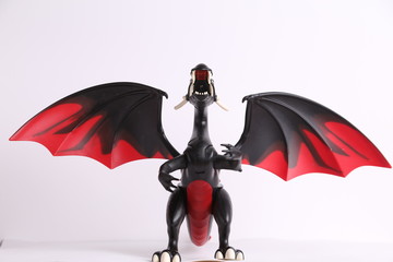 black and red dragon toy on white background