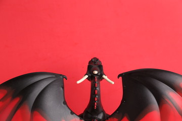 dragon toy black and red on red background