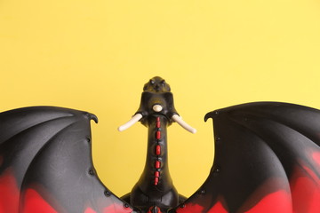 dragon toy black and red on yellow background