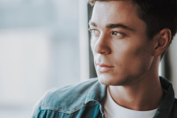 Close up of dark haired man looking into the distance