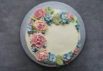 big wedding cake, decorated with buttercream flowers, on the grey stone background - obrazy, fototapety, plakaty