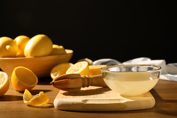 Composition with lemon juice and wooden reamer on table