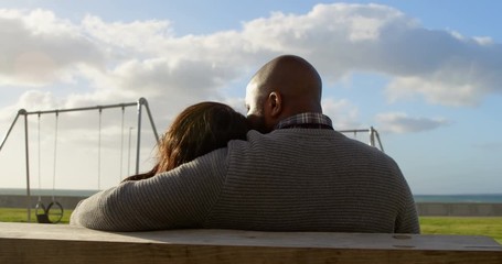 Rear view of couple sitting on bench in the park 4k - Powered by Adobe