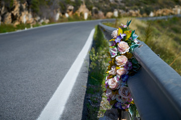 Flowers memorial symbol in a road