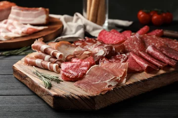 Papier Peint photo Viande Cutting board with different sliced meat products served on table