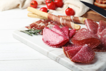 Cutting board with different sliced meat products served on table