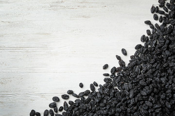 Raisins on wooden background, top view with space for text. Dried fruit as healthy snack
