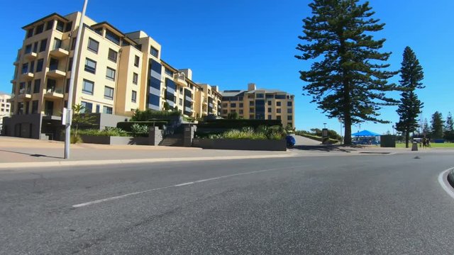 Vehicle POV, driving past the Marina apartments in Glenelg, seaside suburb of Adelaide South Australia.