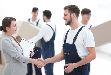 Manager with clipboard shaking hands with movers.