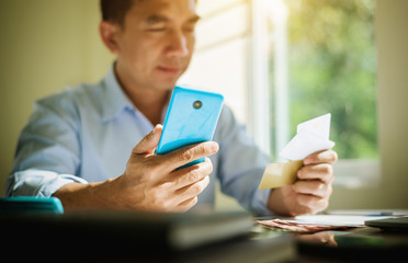 Business man hand hold credit card buying online product mobile applicaion.