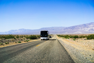 Tour bus driving through Death Valley National Park, California