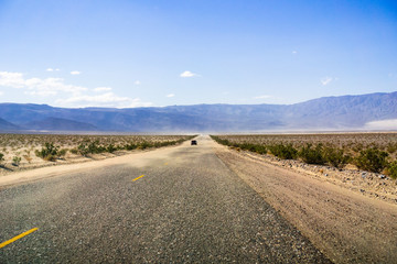 Driving through Panamint Valley; sand carried on the road by wind; Mojave Desert, California