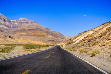 Travelling through Death Valley National Park, moon rising up in the sky; California