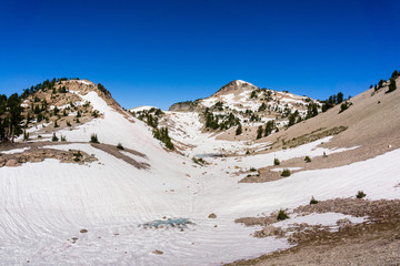 High altitude snow covered peaks and valley on a sunny summer day, Lassen Volcanic National Park, Northern California